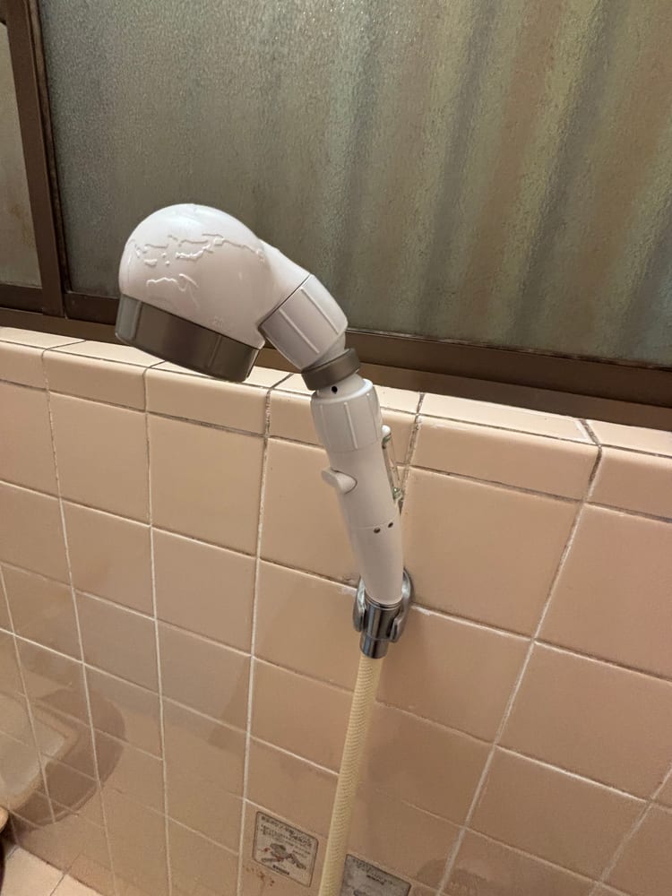 交換後の実家のシャワーヘッド。白い新しいヘッドになった